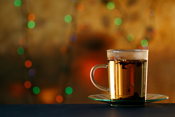 Tea cup with tea leaf sacking on the dark blue table and blur colorful background.