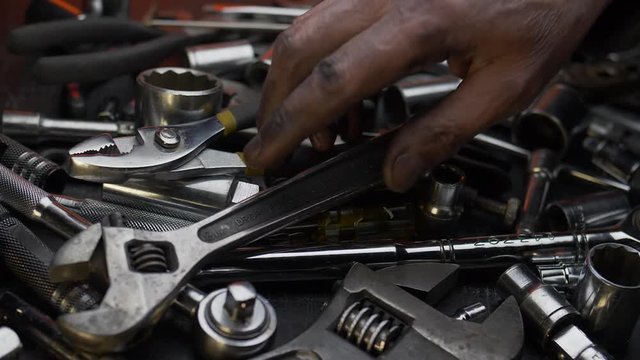 DIRTY HAND CHANGES TOOLS.  SLOW MOTION, CLOSE UP DOLLY SHOT.