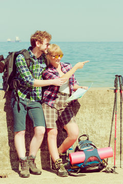 couple backpacker with map by seaside