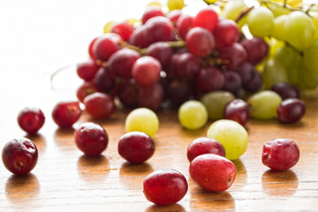 Juicy and ripe grape clusters of green and burgundy grapes on a white background