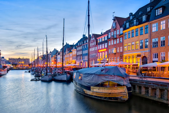 Nyhavn with its picturesque harbor with old sailing ships and colorful facades of old houses in Copenhagen, Denmark