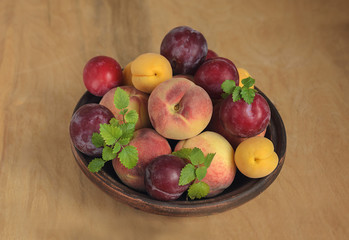 Ripe Persian fruit and plum on a ceramic plate