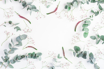 Flowers composition. Round frame made of pink gypsophila flowers and eucalyptus branches on white background. Flat lay, top view, copy space