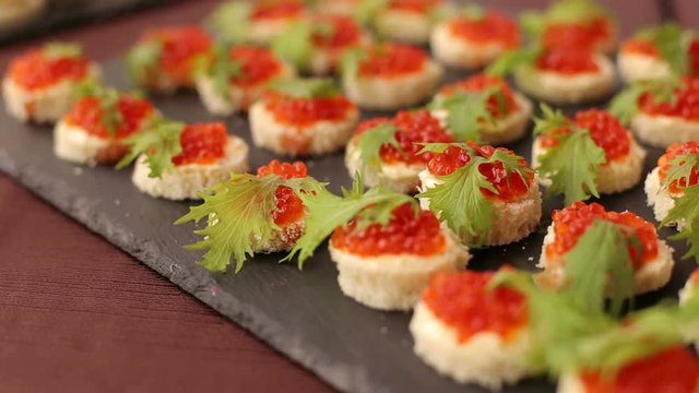 Delicious sandwiches with red caviar at a buffet or Banquet, close-up.