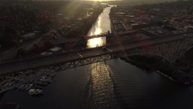 Aerial Panning Down to Cars Driving Across Canal on 2 City Bridges at Golden Hour
