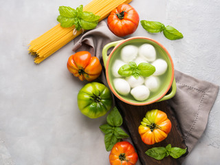 Italian food tomato mozzarella still life on gray rustic background. Traditional products