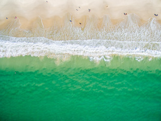 An aerial view of the beach on a clear day with blue water