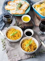 Lunch with curry pasta noodles in bowls and vegetables with turmeric
