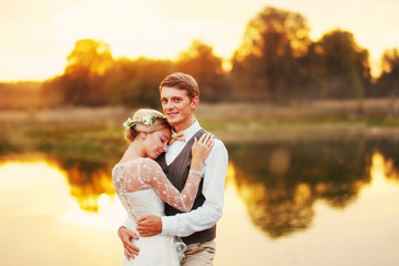 Newlyweds stand in front of a lake