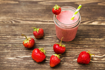 Healthy strawberry smoothie in mug on rustic wood
