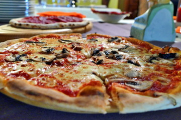 Pizza with mushrooms and olives on table, close up view