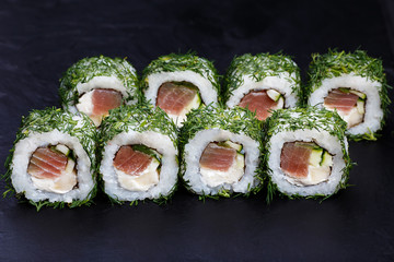 Fototapety  Pyszne rolki sushi z tuńczykiem i serkiem śmietankowym w siekanym koperku podawane na czarnym łupku, z bliska. Smaczne japońskie jedzenie?