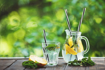 Jug of tasty refreshing homemade lemonade on wooden table. Summer, healthy drink. Toned image