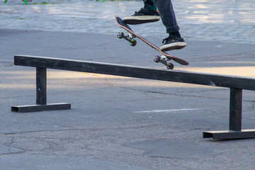 Fototapeta na wymiar Skateboarder legs riding skateboard at skatepark