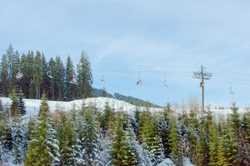 Skiers ascend on the ski lift in the mountains