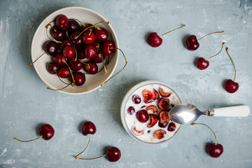 Homemade breakfast with white plain yogurt, muesli and cherries on the wooden background