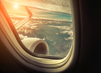 Fototapeta premium Beautiful view from porthole of airplane on sky with clouds und