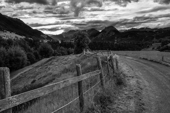 Small rural road and old wooden fence in the countryside near Axams Austria 