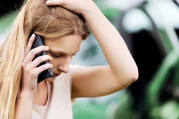 Female criver making phone calls after traffic accident.