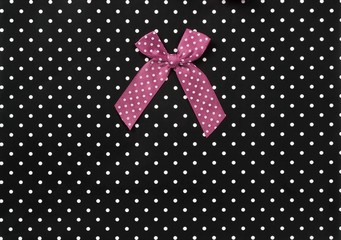 Bow on a black background with white dots	