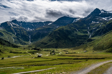 Summer day in blooming green Alpine valley surrounded by the mountain scenery 