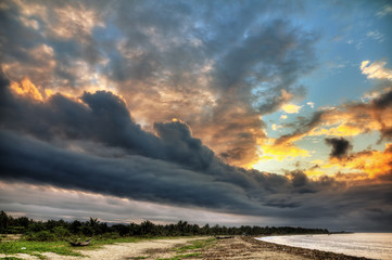 Obraz na płótnie Canvas The coastline of Maroantsetra in Madagascar at sunrise, with a dramatic sky