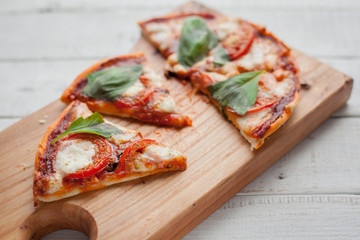 Delicious Italian pizza Margherita on a white wooden table. Top view