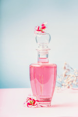 Bottle of lotion or perfume with pink flowers , natural cosmetic product or beauty concept on...