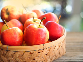 Red ripe apples fruit in bamboo basket.