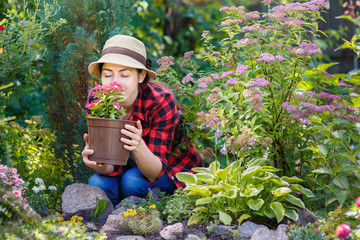 gardener girl smelling flowers in garden