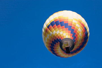 Naklejka premium Colorful hot-air balloon in flight seen from below