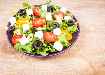 Greek salad with fresh vegetables, feta cheese and black olives.