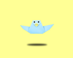 blue origami bird on yellow background,minimal concept