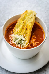 italian minestrone soup with garlic bread and grated cheddar cheese