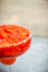 Cocktail strawberry margarita on the wooden background. Selective focus.