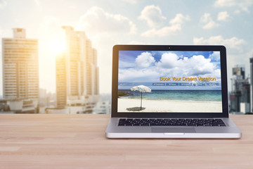 Travel, holiday , vacation planning concept : laptop with website book your dream vacation on screen at office work space for business people planning trip for relax on holiday