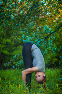 beautiful woman doing yoga outdoors On green grass