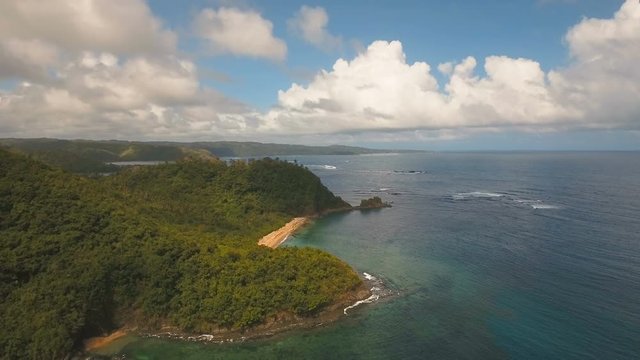 Aerial view: beach, tropical island, bay and lagoon. Tropical landscape sky, clouds and mountains rocks with rainforest. Aerial: Blue lagoon in the ocean. Aerial video.Seascape. 4K video. Travel