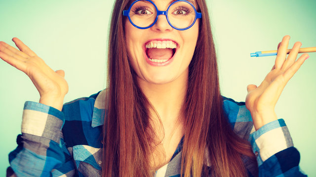 Happy nerdy woman in glasses holding pen