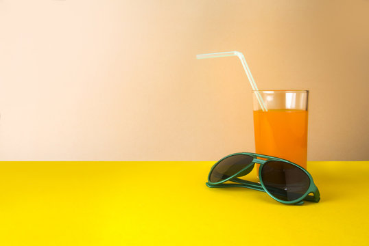 orange juice drink and sunglasses in summer concept