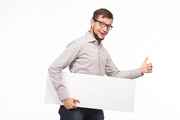 Young happy man portrait of a confident businessman showing presentation, pointing paper placard gray background. Ideal for banners, registration forms, presentation, landings, presenting concept.