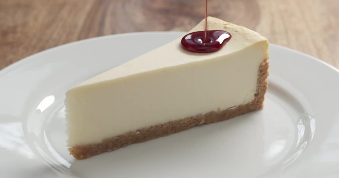 Slow motion of cherry jam pour over traditional new york cheesecake