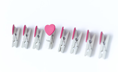 wooden clothes pin or cloth pegs with heart shape design on a white background