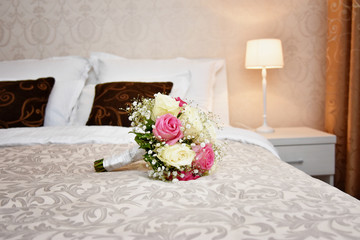 Wedding bouquet on bed in hotel room