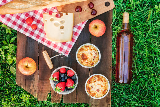 Picnic food and rose wine on wooden board with copyspace