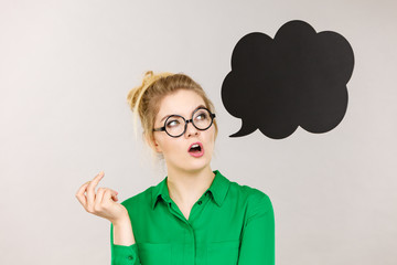 Woman holding black thinking bubble