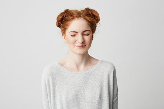 Portrait of young cute foxy girl laughing with closed eyes over white background.
