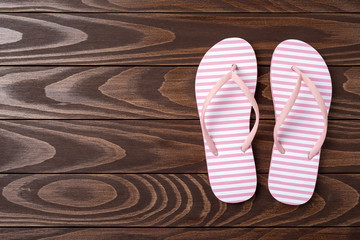 Overhead shot of pink flip flops on wooden background