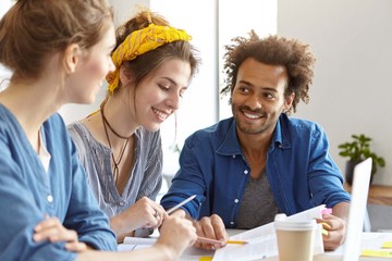 Cheerful mixed race people meeting together discussing main issues of their work. Multiethnic...