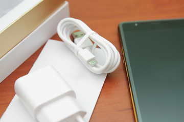 Black smartphone lying on a wooden table